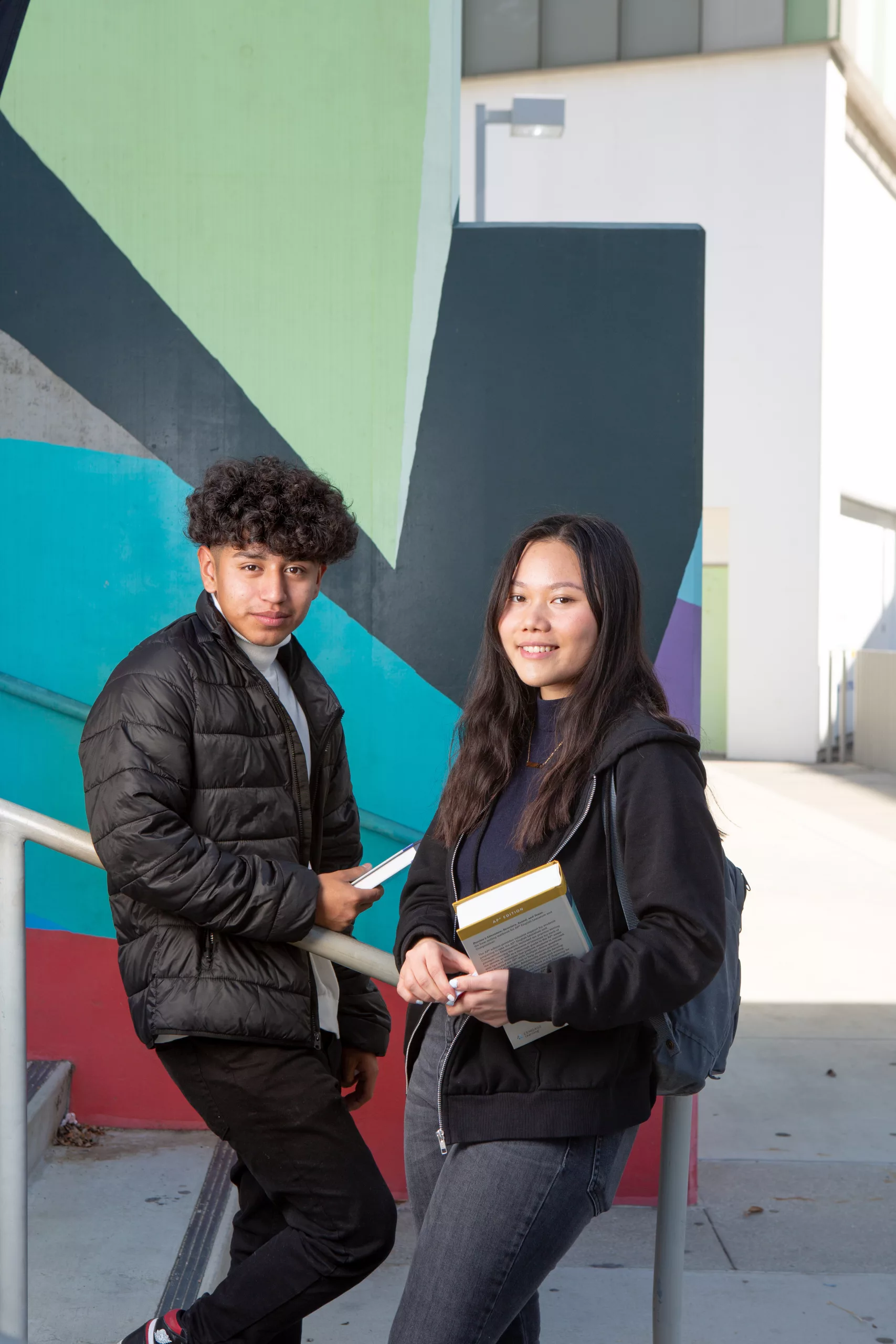 Two high school students holding books.